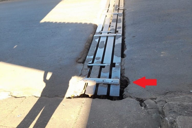 Em destaque, a  fenda existente entre o asfalto e a grelha