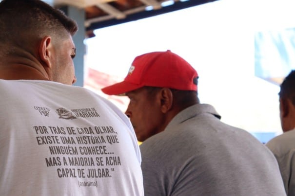 Duas pessoas em situação de rua, posicionadas de costas, durante evento da Semana da Visibilidade de Pessoas em Situação de Rua