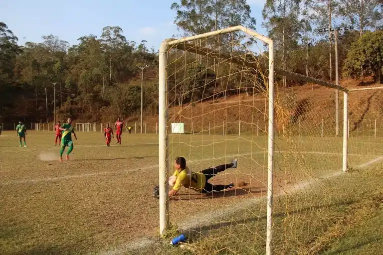 Goleiro do Bandeirantes pula para defender pênalti cobrado por um jogador do 8 de Dezembro, em partida válida pela 4ª rodada do Campeonato Amador de Mariana