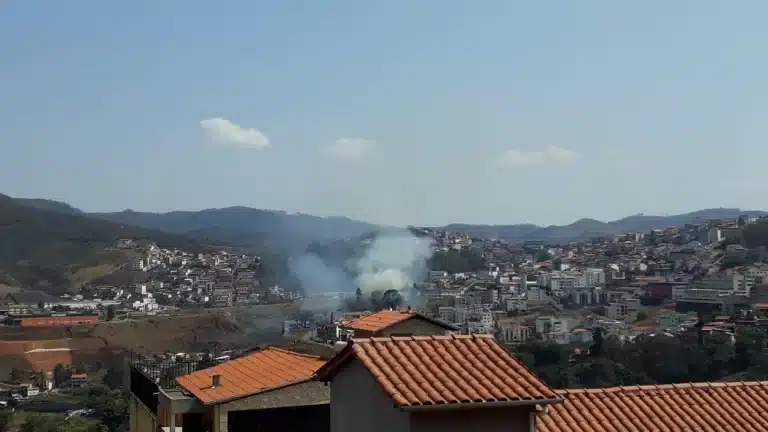 Panorâmica do município de Ouro Preto, onde é possível visualizar a fumaça de incêndio próximo a residências e árvores