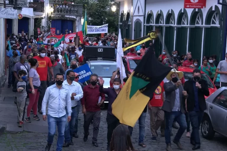 Manifestantes, tendo um vereador á frente, empunhando bandeira de Ouro Preto, dirigiram-se á Prefeitura Municipal para a entrega oficial do relatório da CPI da Saneouro, em outubro de 2021. Agora, o Ministério Público recomendou o arquivamento da investigação