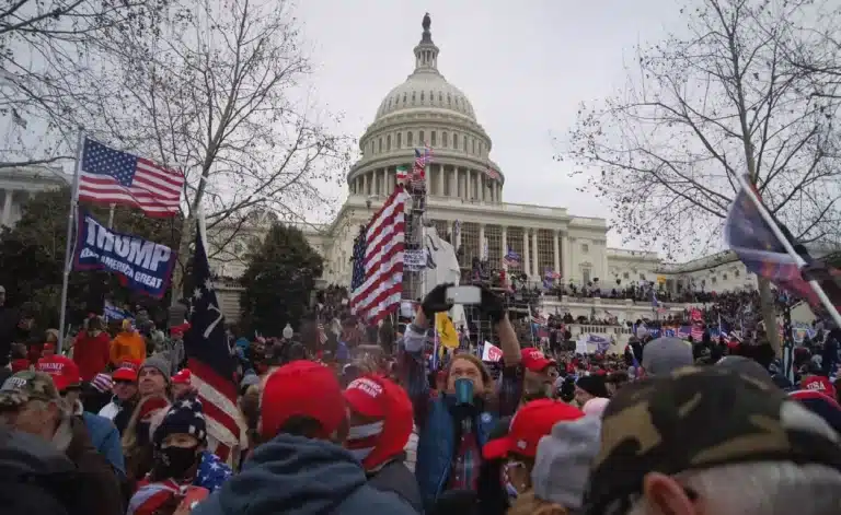 Com roupas de frio e portando bandeiras dos Estados Unidos, manifestantes se concentram diante do Capitólio, em ato considerado contrário à democracia