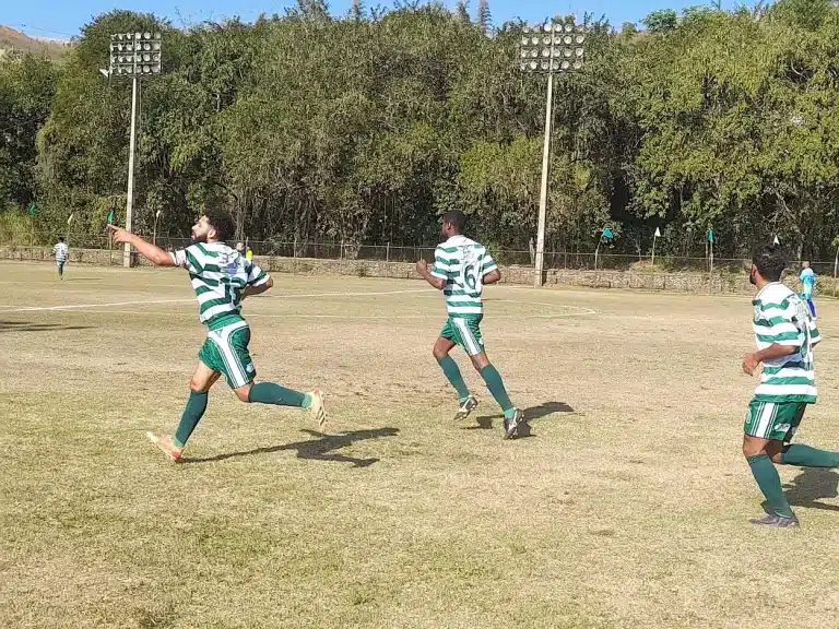 Jogadores do Guarany, com calções verdes e camisas com listras horizontais em verde e branco, comemoram o primeiro gol marcado contra o Cachoeirense
