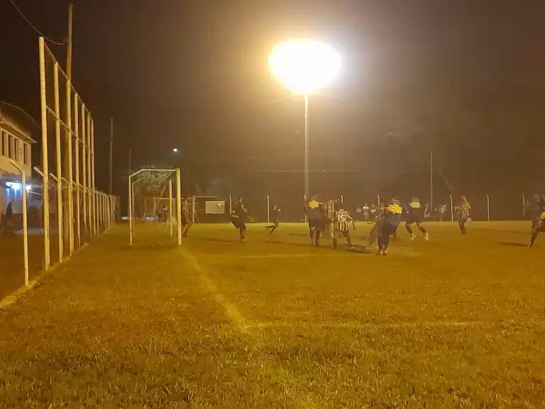 Jogadores do Reunidos e do Morro Santana disputam jogada em partida noturna com iluminação deficiente