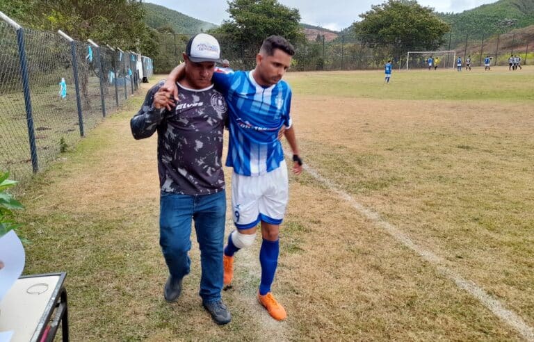 Gabriel, centroavante do São Caetanense, com o joelho direito contundido, é amparado para deixar o campo, fazendo a torcida temer pelo sonho de ser campeão dos juniores