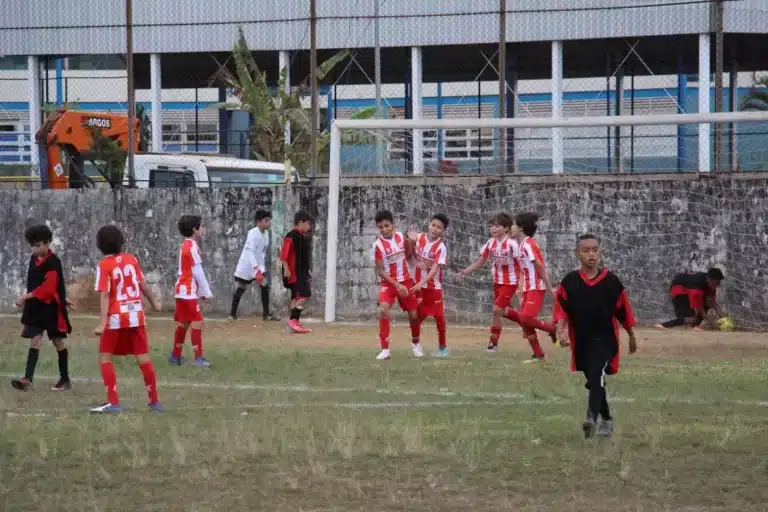 Jogadores do 1º de Maio, categoria sub-11, com uniformes em vermelho e branco, comemoram um dos gols que garantiu a presença da equipe nas finais do futebol de base de mariana