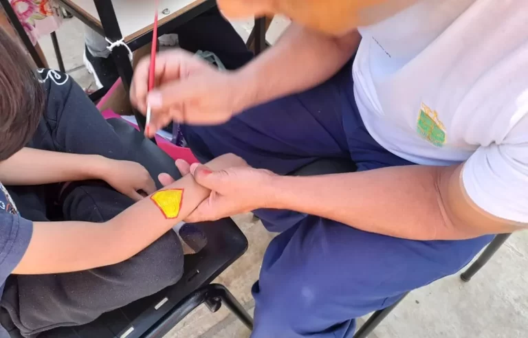 Braço de uma criança sendo pintado com temática de super-herói, durante a Ação Transitolândia