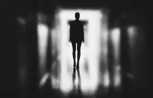 Silhueta de mulher, em um ambiente escuro, ilustrando a crônica "Corpo de Delito"
