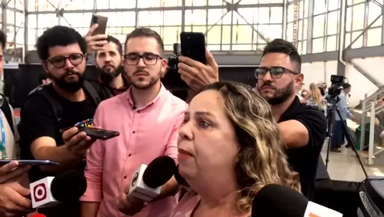 Atingida, rodeada por repórteres, faz declaração durante evento da Fundação Renova