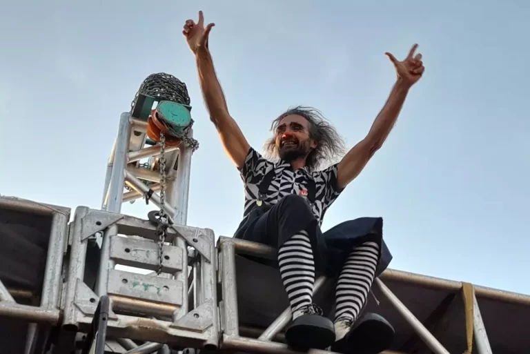 Palhaço, sentado na cobertura da tenda instalada na Praça da Sé, acena para os participantes do Encontro de Palhaços