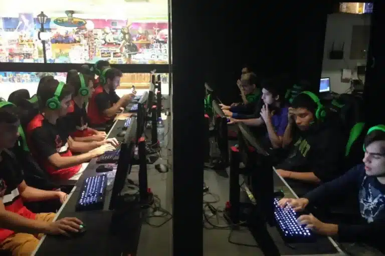 Montagem com equipes adversárias de eSport, disputando uma partida em computadores