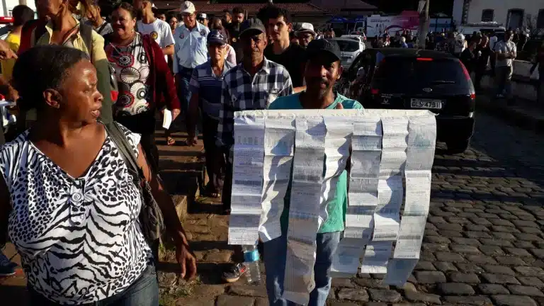 Manifestante transforma contas de água em cartaz, durante um dos muitos protestos pedidndo a remunicipalização