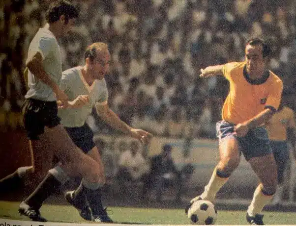 Tostão, com a bola, recebe o combate de dois jogadores uruguaios, na partida das semifinais da Copa do Mundo de 1970.