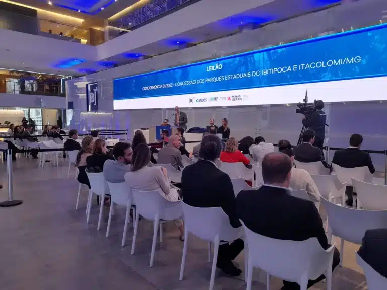 Pessoas assentadas de costas, participam do leilão de concessão do Parque do Itacolomi
