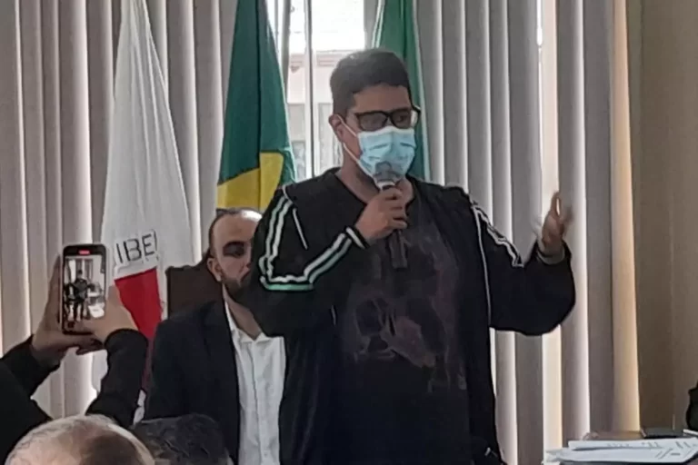 Homem de máscara, portanto microfone, faz pronunciamento em favor da proibição de fogos com estampido, durante reunião da Câmara de Mariana