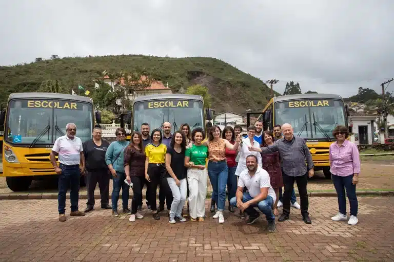 Várias pessoas diante de três novos ônibus escolares adquiridos pela Prefeitura de Ouro Preto