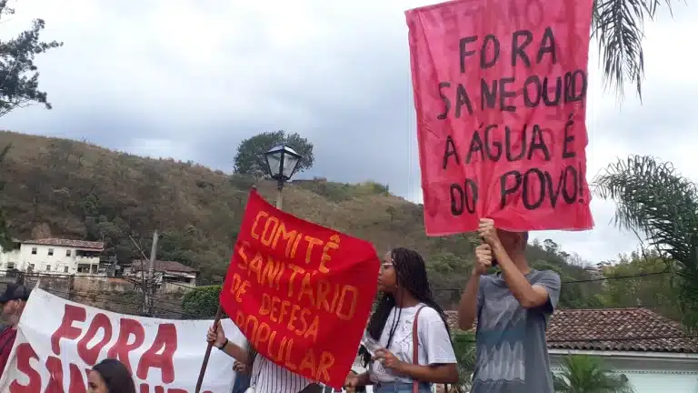 Manifestantes, insatisfeitos com a Saneouro, portam faixas e cartazes do movimento "Fora Seneouro"