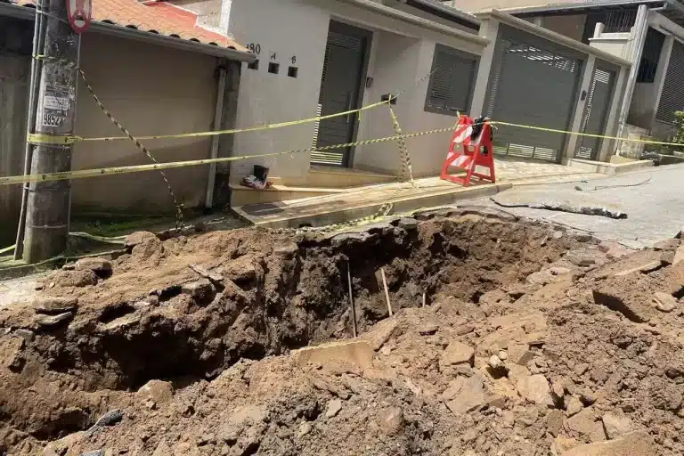 Situação da rua João Batista, na manhã de sexta-feira (13), durante os trabalhos de intervenção executados pela equipe da Secretaria de Obras, vendo-se um grande buraco com terr aos lados, sinalizado com cavaletes e fitas de interdição ao tráfego