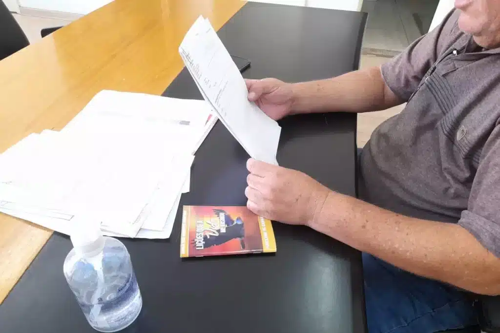 O livro sobre a mesa de trabalho de Edson Agostinho foi um presente de um pastor evangélico