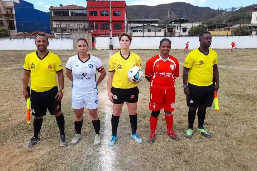 Júlia Pires, ladeada pelos assistentes e capitãs do 1º de Maio e do Olimpic, é a primeira árbitra a apitar uma partida do futebol feminino em Mariana