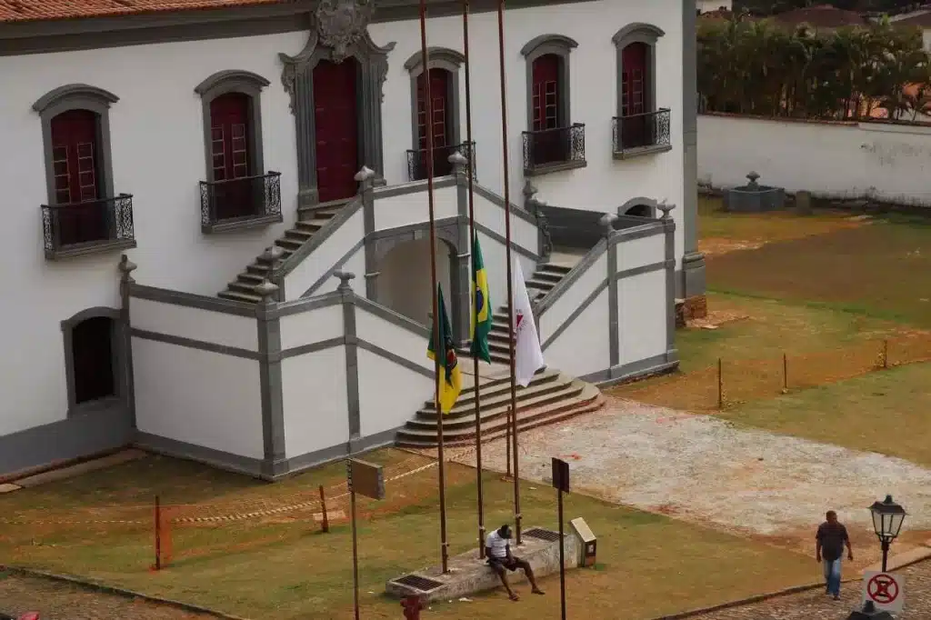 Com luto oficial decretado pela Prefeitura de Mariana, devido ao falecimento de Dom Geraldo Lyrio, as bandeiras ficaram hasteadas a meio mastro, diante da Câmara Municipal, na Praça Minas Gerais