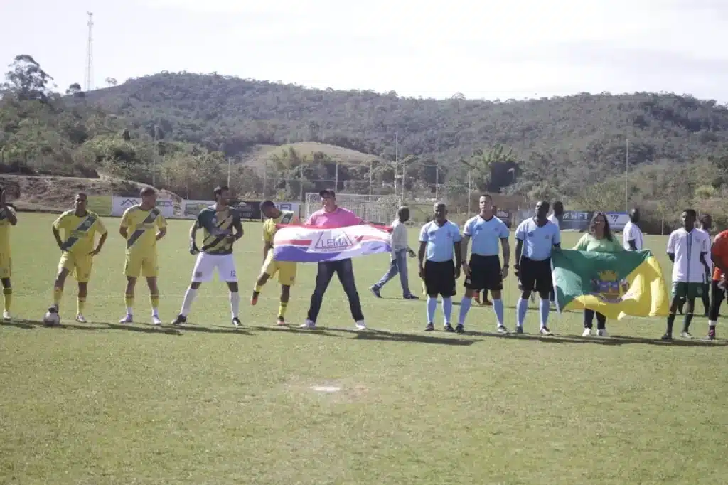 Bandeiras da Liga Esportiva e do município, durante cerimônia de abertura do Campeonato de Mariana