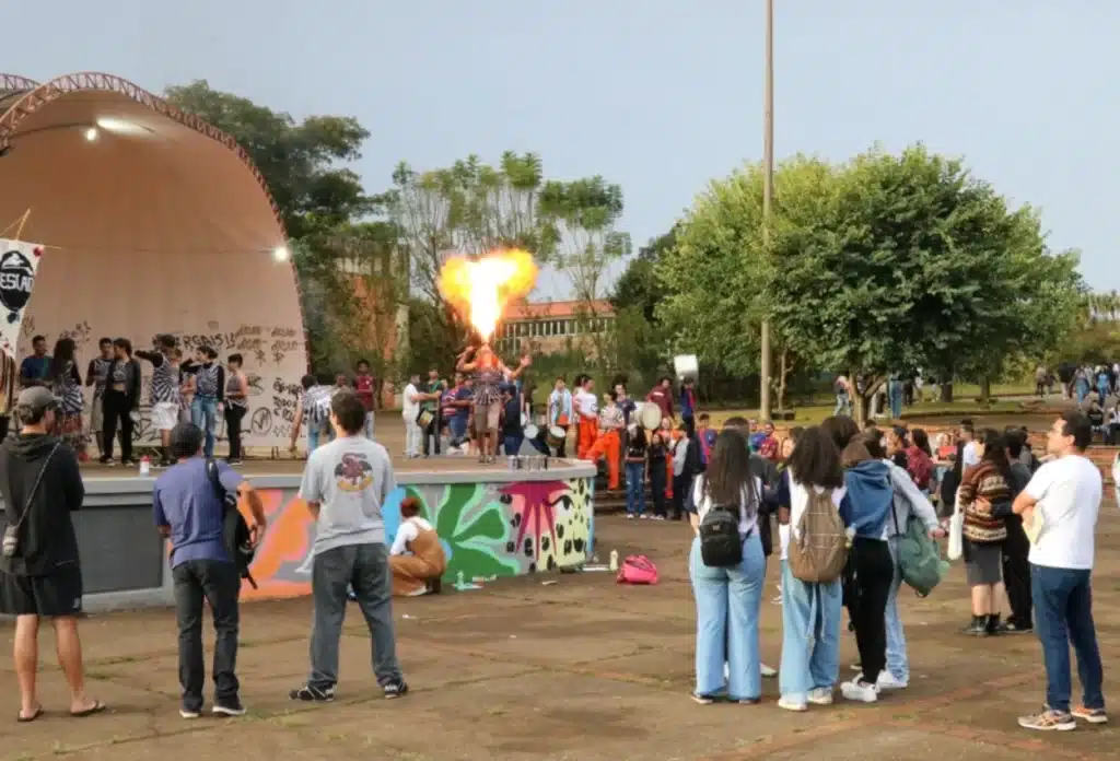 Jovens assistem show diante de uma concha acústica