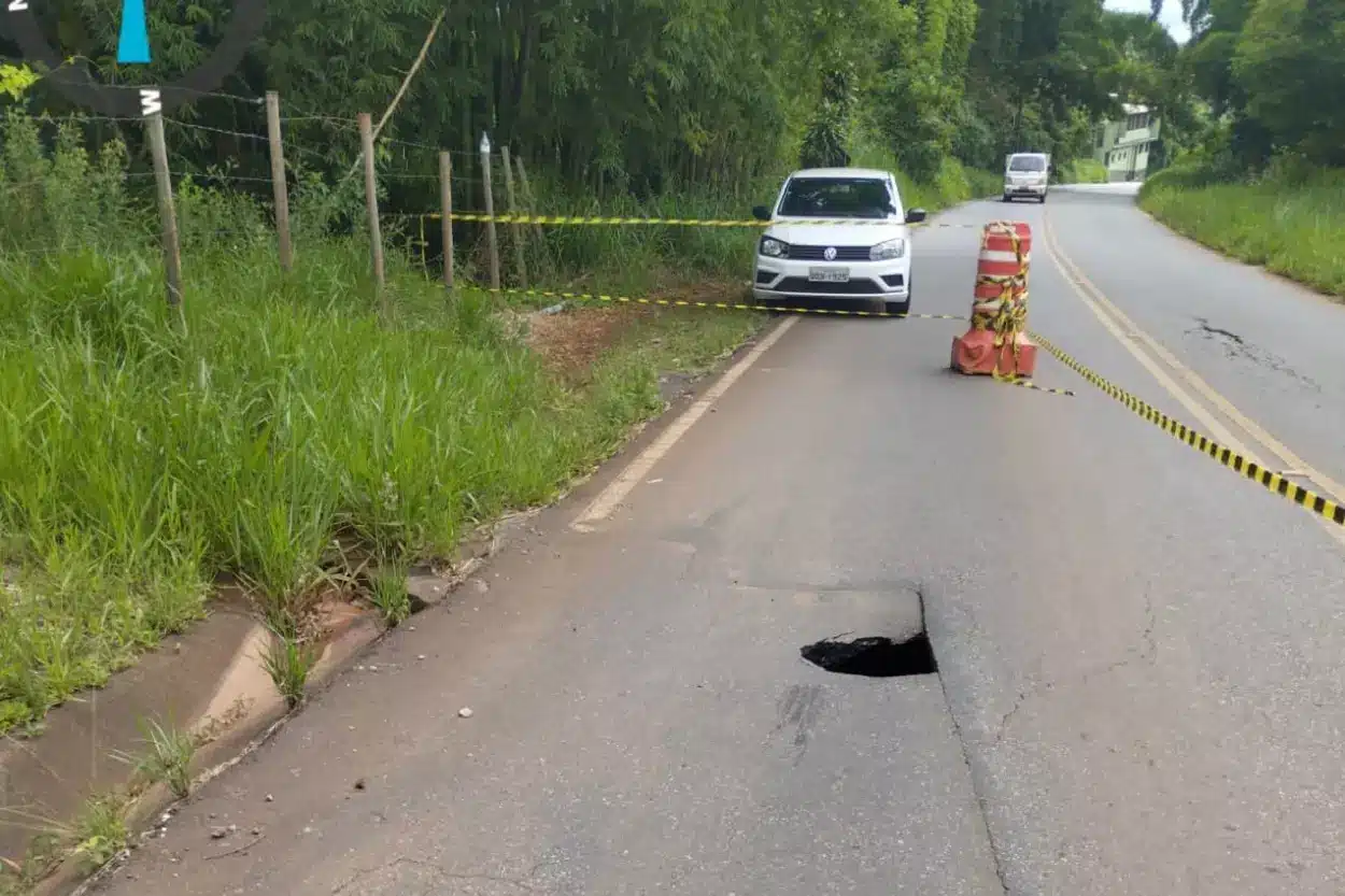 Buraco na pista da rodovia AMG-1730, com formação de grande cratera abaixo do pavimento asfáltico