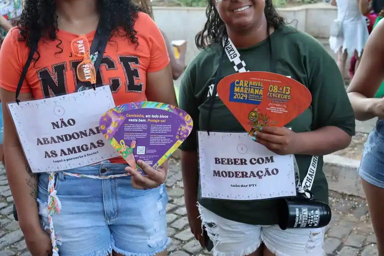 Grupo de foliãs, no desfile da Banda dos Farrapos, portando leques com mensagens de conscientização da campanha instituída pela Administração Municipal