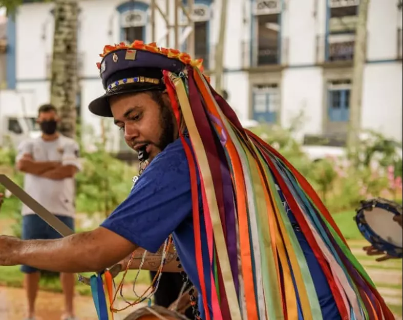Homem com chapéu decorado e fitas coloridas participa de celebração do congado em Mariana, Minas Gerais, Homem com chapéu decorado e fitas coloridas participa de celebração do congado em Mariana, Minas Gerais, que valoriza a cultura africana.