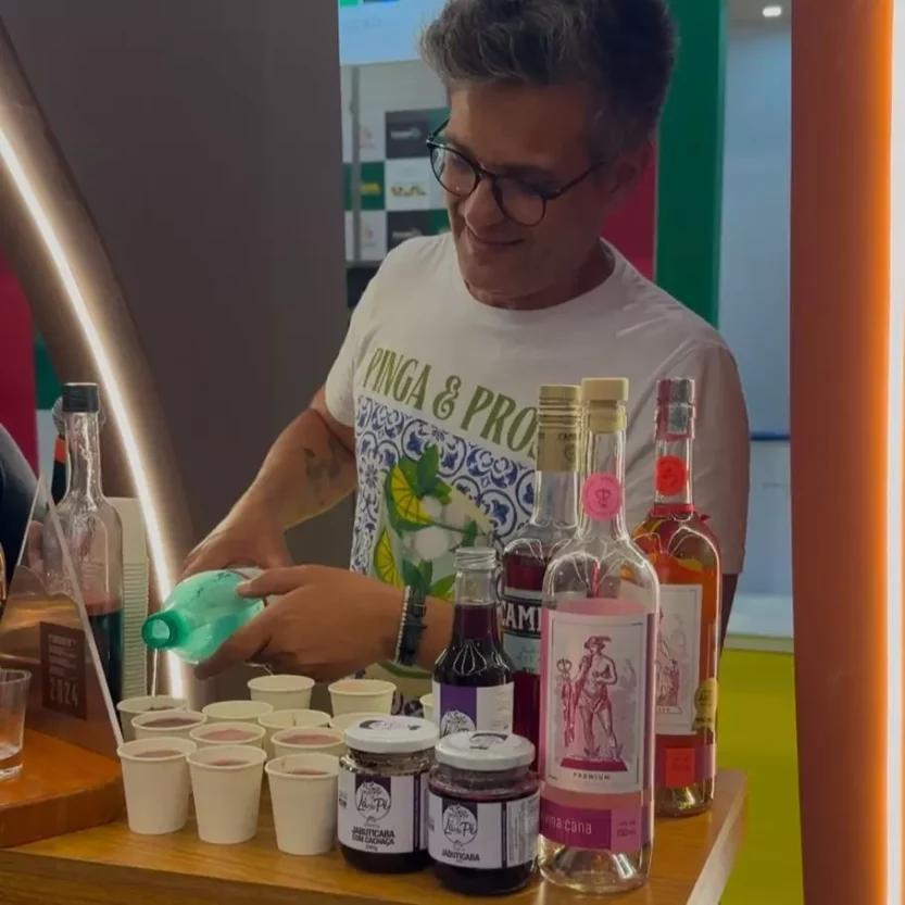 Homem preparando bebidas com jabuticaba em estande na WTM Latin America 2025.