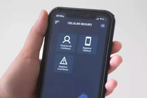 Pessoa segura um celular com a tela aberta no aplicativo Celular Seguro.