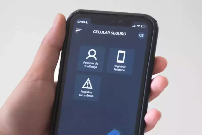 Pessoa segura um celular com a tela aberta no aplicativo Celular Seguro.