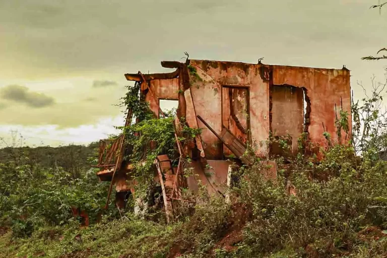 A imagem mostra uma das casas de Bento Rodrigues em ruínas após o rompimento da Barragem de Fundão que gerou o PID.