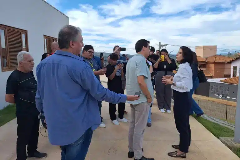 A imagem mostra uma advogada da Samarco conversando com jornalistas da imprensa local.
