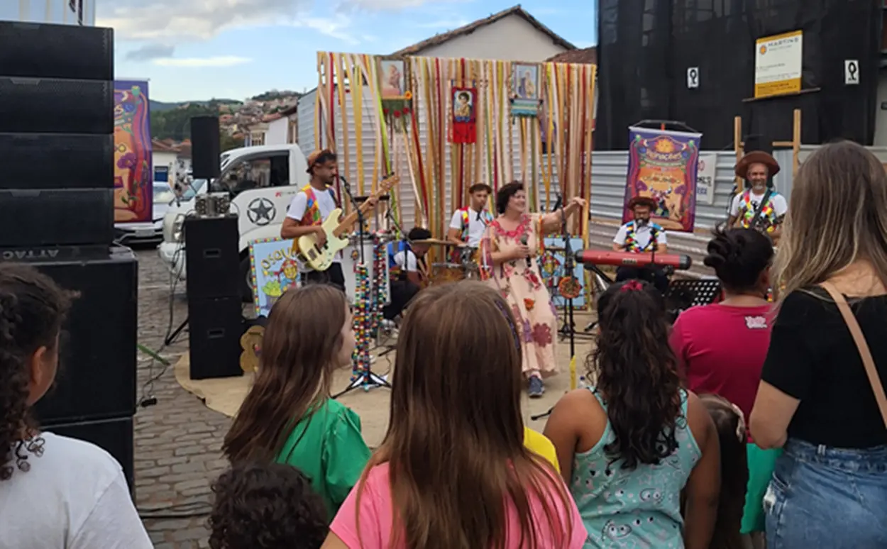 Grupo musical se apresenta ao ar livre para crianças e famílias durante a Semana Mundial do Brincar.