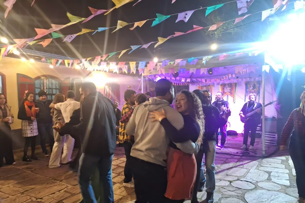 Casais dançam forró no Bar da Nida durante arraiá.