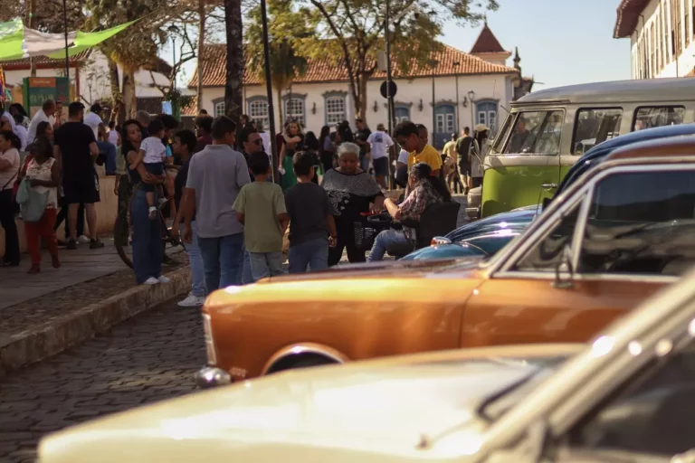 Várias pessoas e veículos antigos no Jardim de Mariana