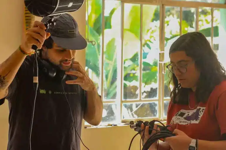 Duas pessoas manuseiam equipamentos para o curta Arte da Guerra.