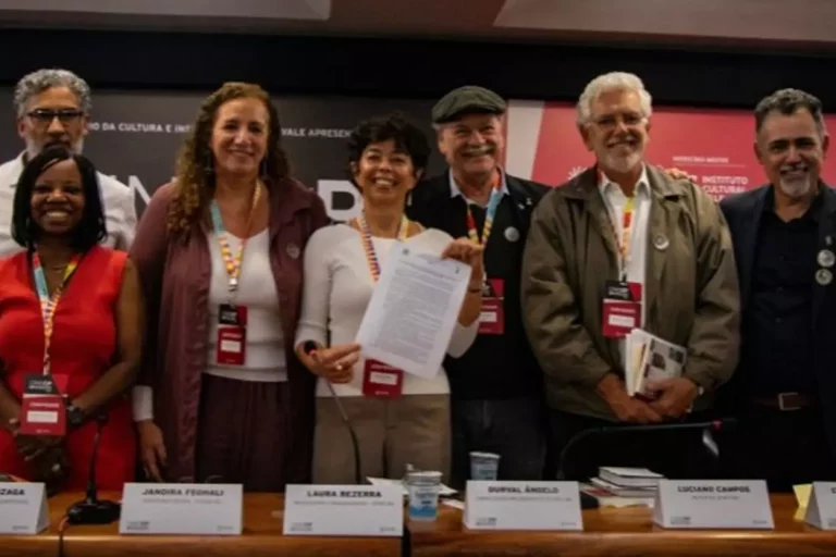 Grupo de sete pessoas, entre autoridades e representantes culturais, posam sorrindo após a assinatura do protocolo de intenções do bacharelado em Cinema e Audiovisual da UFOP.