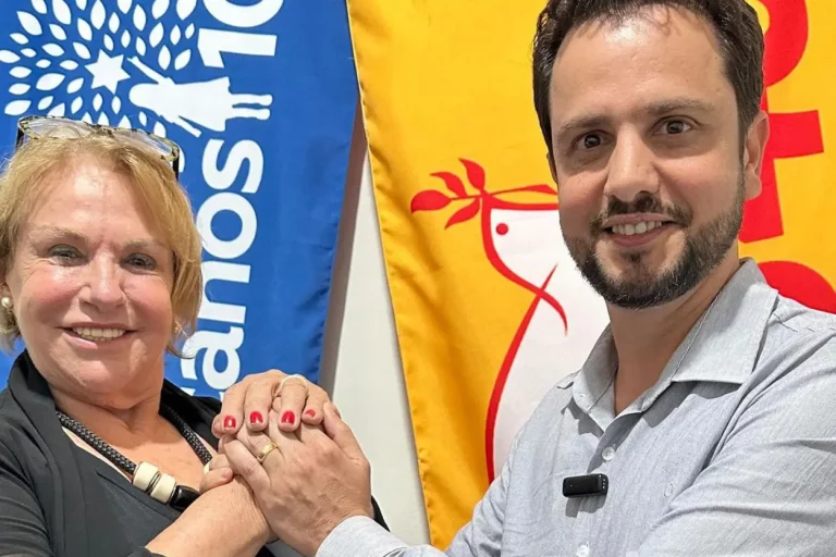 Prefeito e vice-prefeita de Mariana, Sônia Azzi em frente às bandeiras de seus respectivos partidos