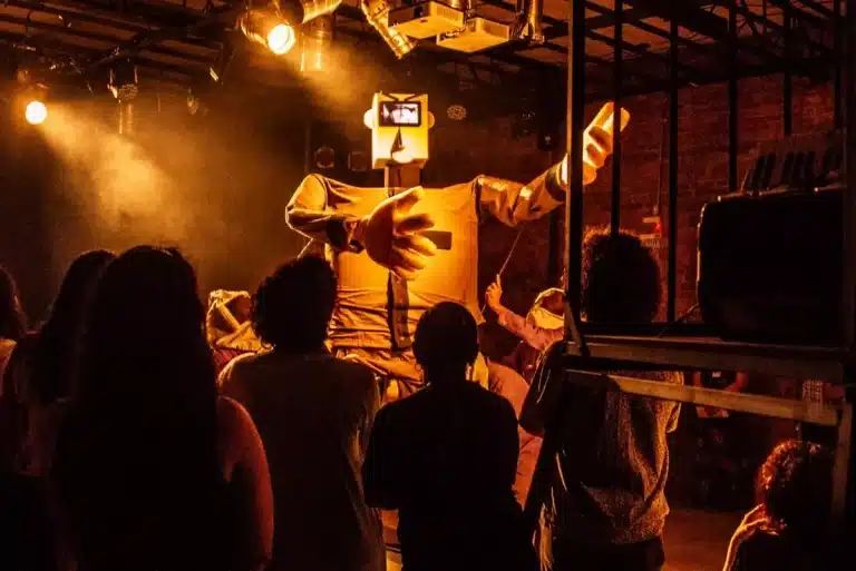Público observa um boneco gigante durante o espetáculo teatral interativo Uiraçu.