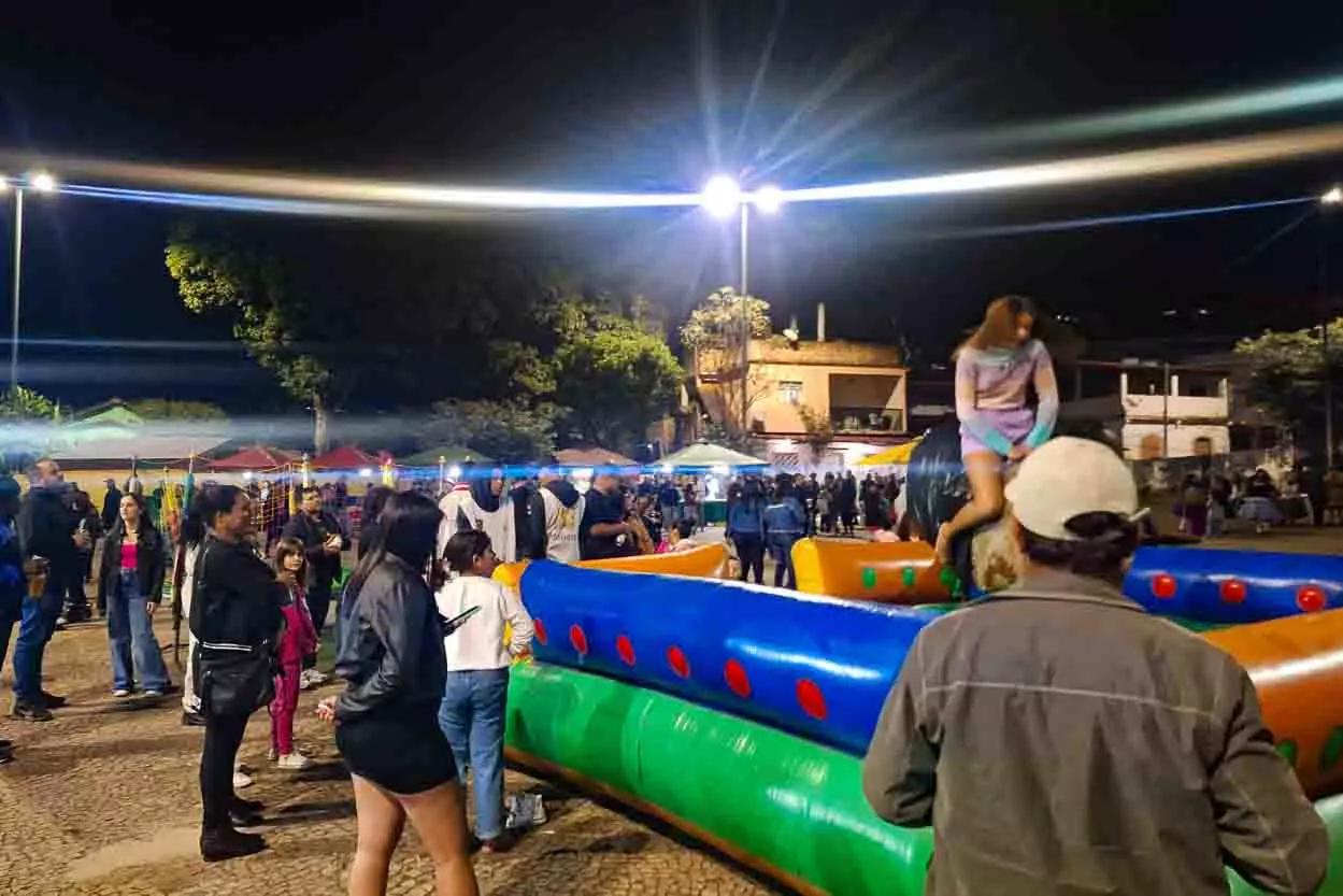 Crianças brincam nos brinquedos da Feira Noturna