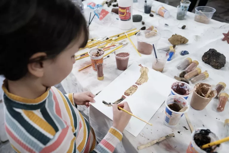 Criança pinta em um papel em oficina realizada no Sextas Abertas, nessa edição terá uma oficina sobre Palestina