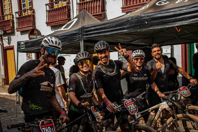 ciclistas dando um hang lose pra câmera e sorrindo