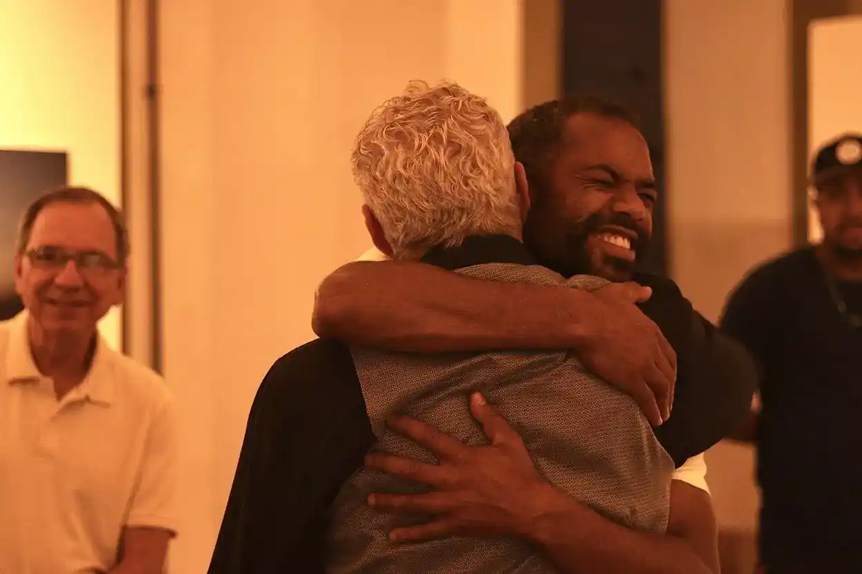 Fotógrafos Eduardo Tropia e convidado Alisson Lessa em abraço caloroso no início da abertura da exposição DESVIA em Ouro Preto Foto: Joyce Campolina/Agência Primaz