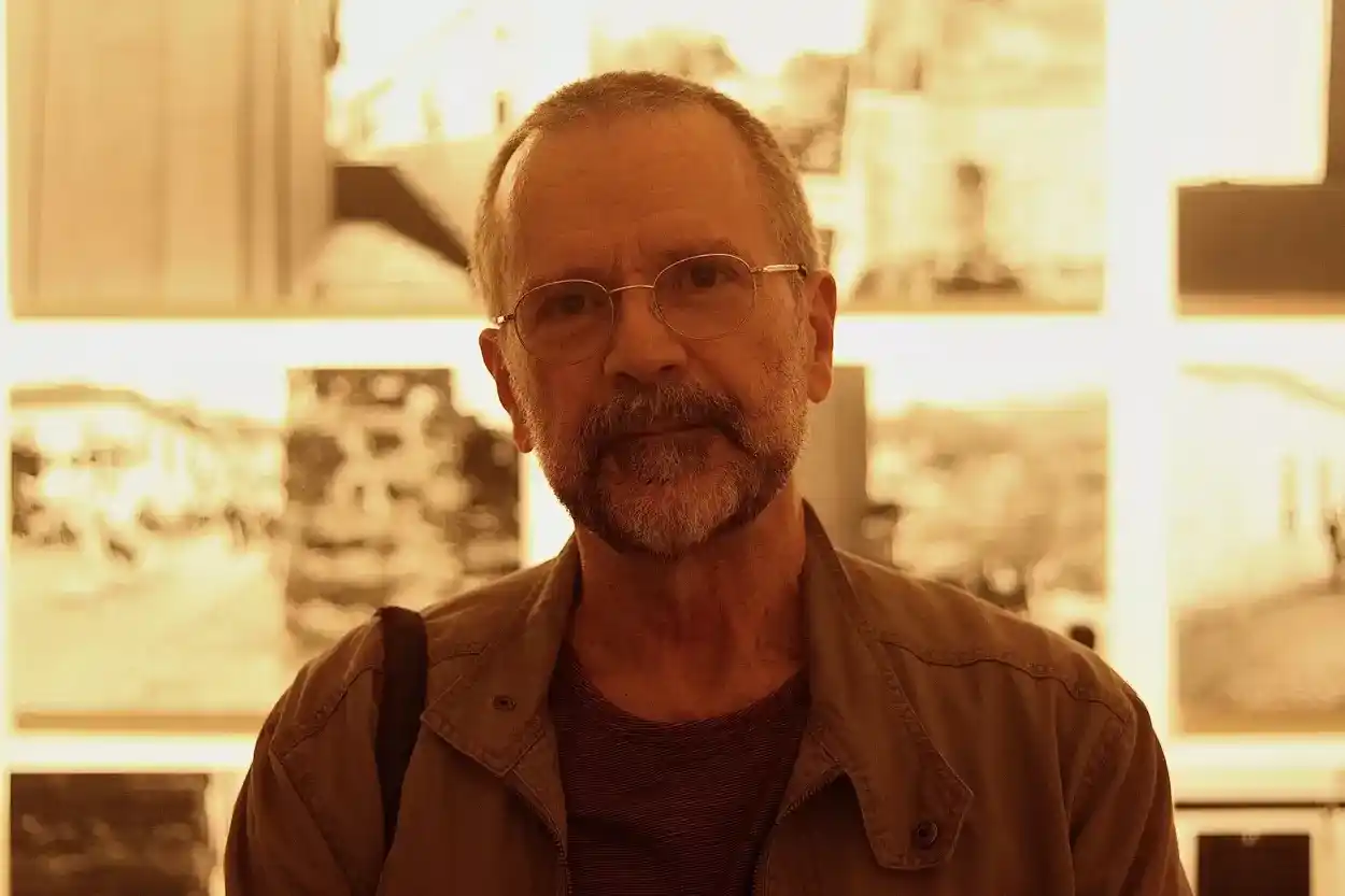 Fotógrafo e exibidor Alexandre Martins em frente ao seu projeto exposto em Ouro Preto. A ideia é celebrar os desvios proporcionados pela cidade. “Meio quadro, meio parede, meio caminho”, explica. - Foto: Joyce Campolina/Agência Primaz