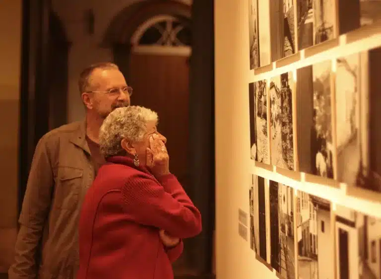 O fotógrafo Alexandre Martins, integrante do Coletivo Olho de Vidro, observa junto com uma visitante o seu projeto em exibição na exposição DESVIA.“Trabalhei o desviar que Ouro Preto está sempre proporcionando, qualquer esquina proporciona”, afirma. - Foto: Joyce Campolina/Agência Primaz