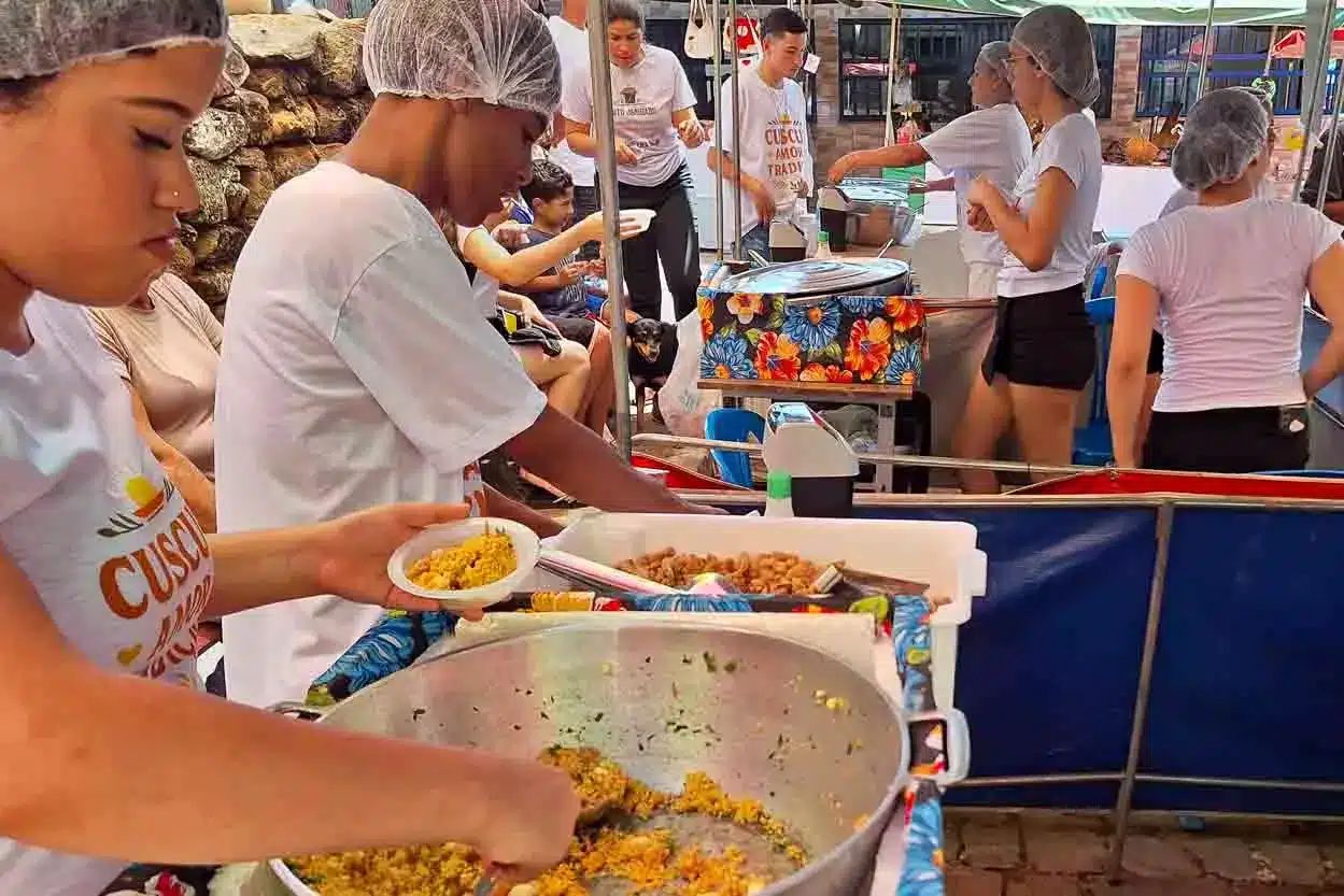 Pessoas servindo cuzcuz durante festival em Sumidouro