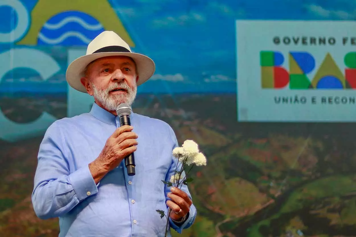 Lula segura uma flor e comemora a isenção do ir, promeçade campanha